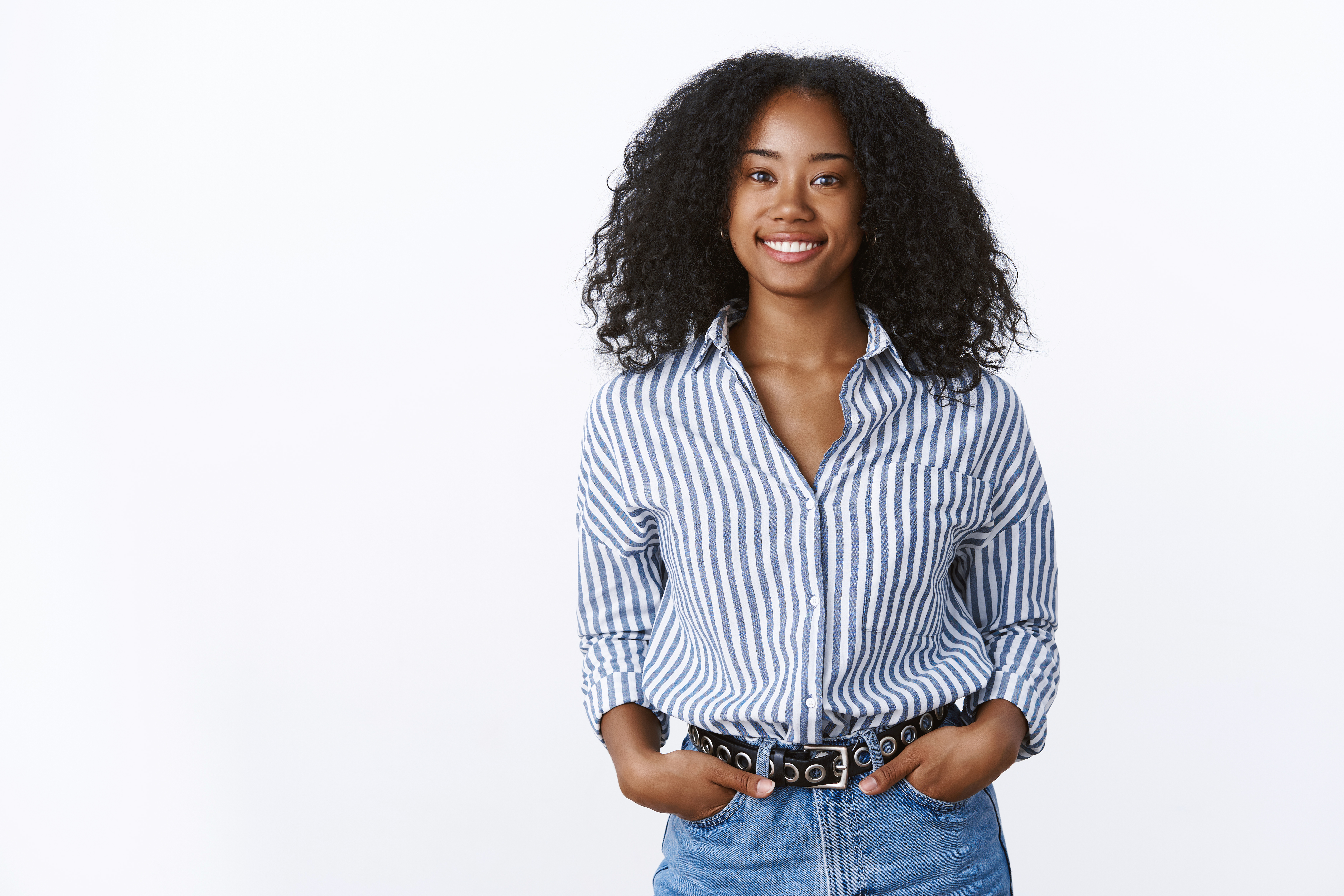 Charismatic cheerful attractive african american woman curly haircut wearing shirt holding hands pockets confident outgoing smiling, talking pleasant conversation, feeling self-assured relaxed.