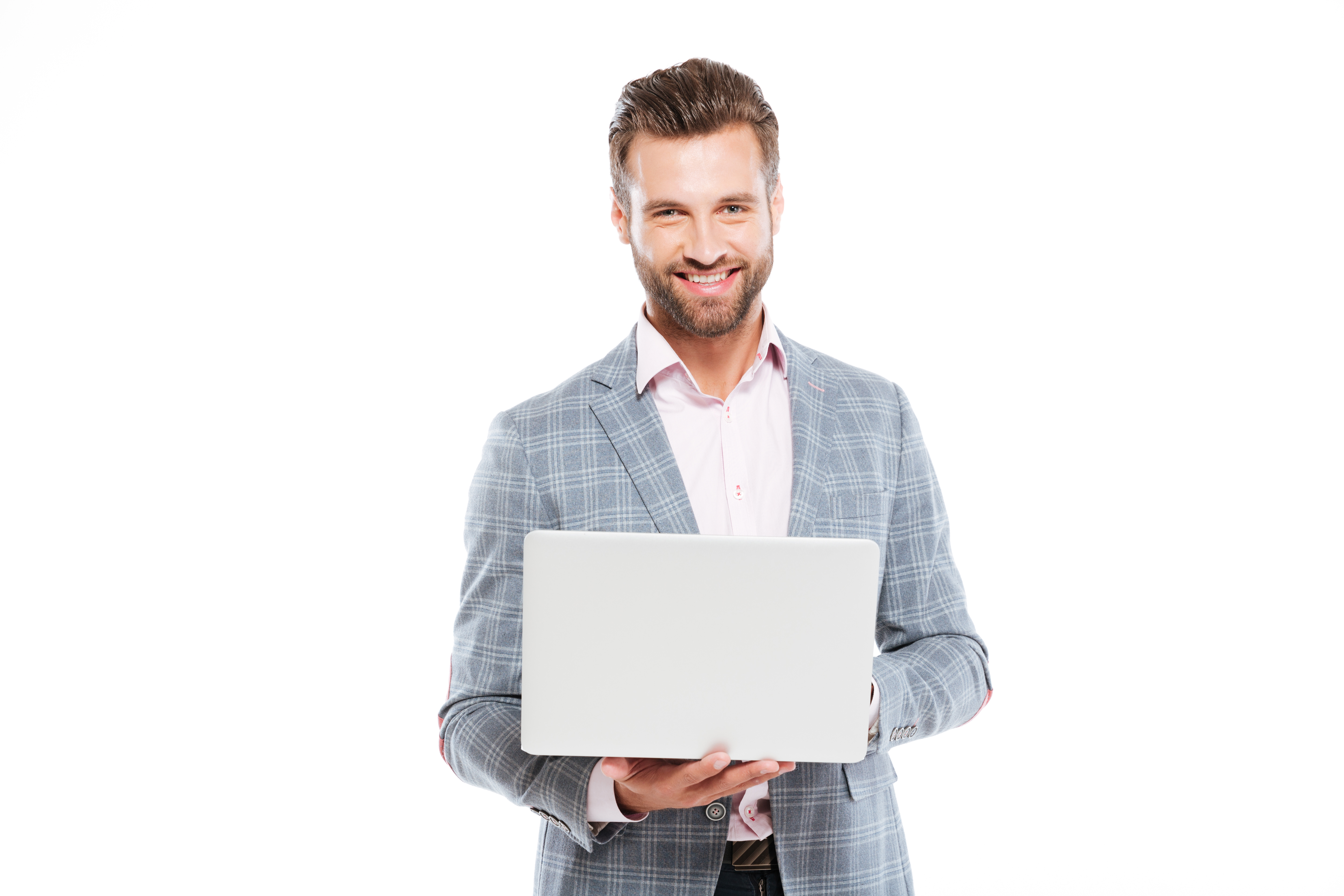 Image of happy young man standing isolated over white background and using laptop computer. Looking at camera.